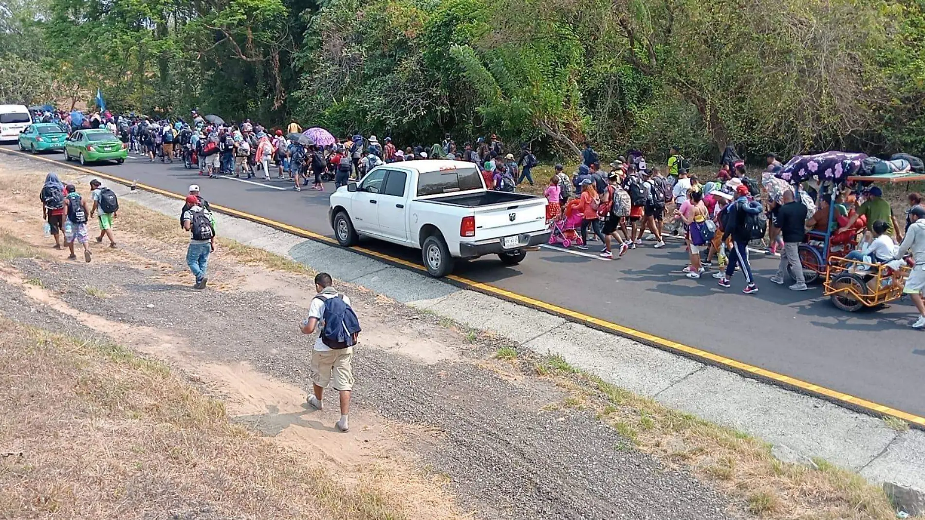 migrantes caminando en la carretera